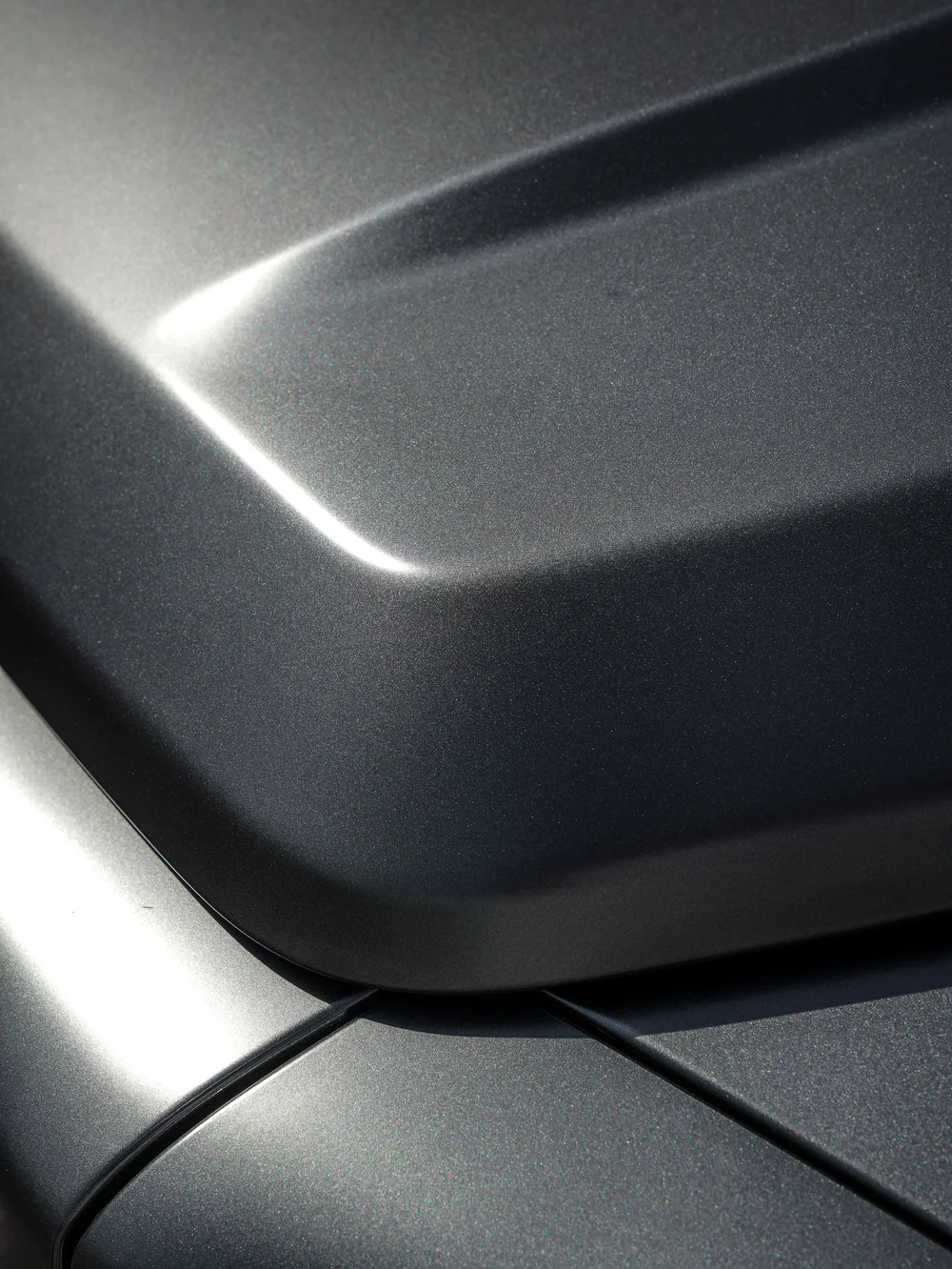 Close view of the satin grey Mercedes-AMG G 63 hood contour and panel junction with a soft light reflection