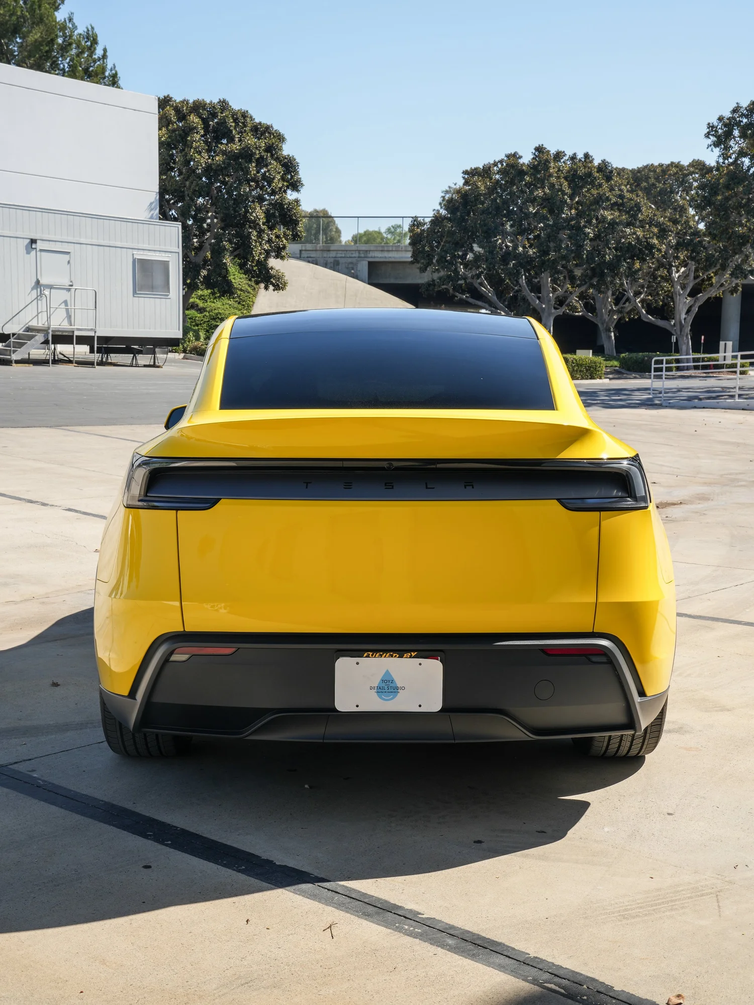 Tesla Model Y with Vegas Yellow vinyl wrap, direct rear view