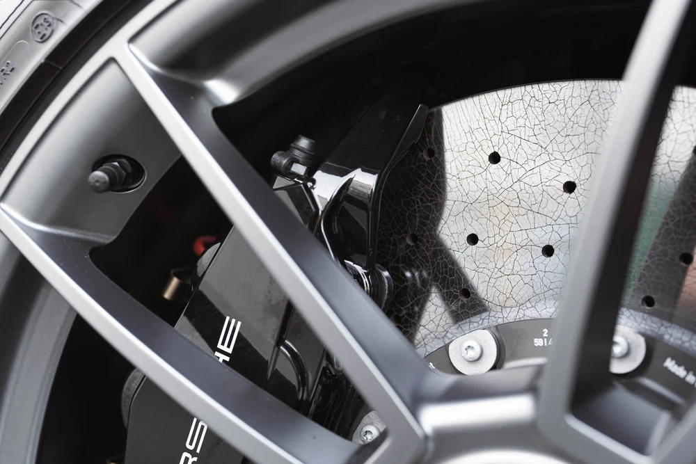 Signal Green Porsche 911 Turbo S, wheel spokes, Porsche caliper and drilled brake disc close-up