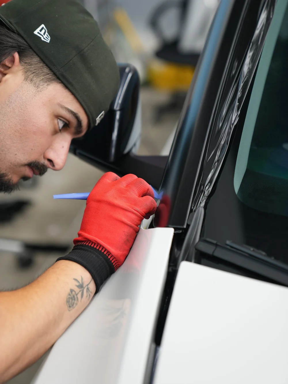 Installer working with a blue tool beside side-window trim in the original Model Y project gallery