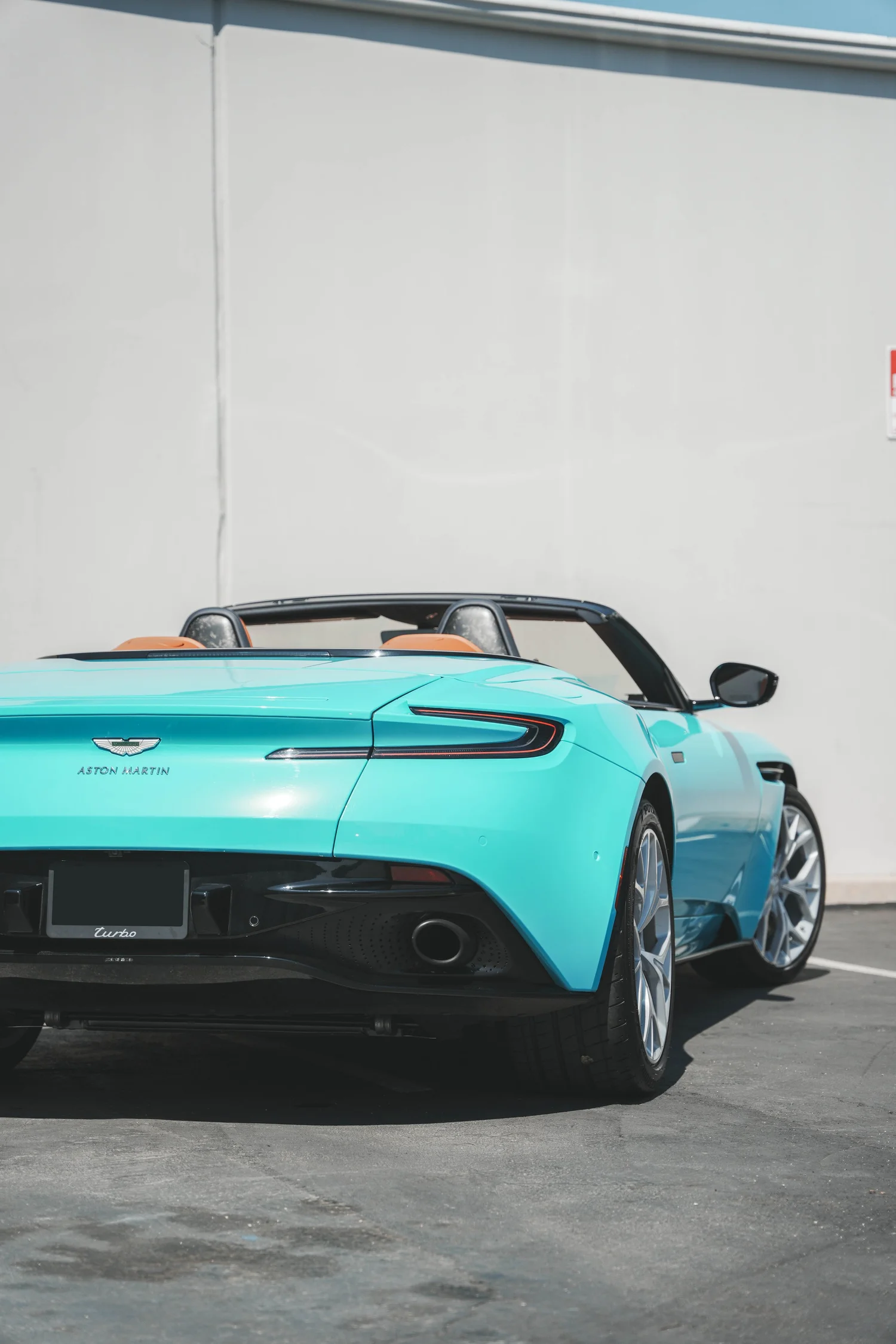 Aston Martin DB11 Miami Blue after Vinyl Wrap, low-angle rear view