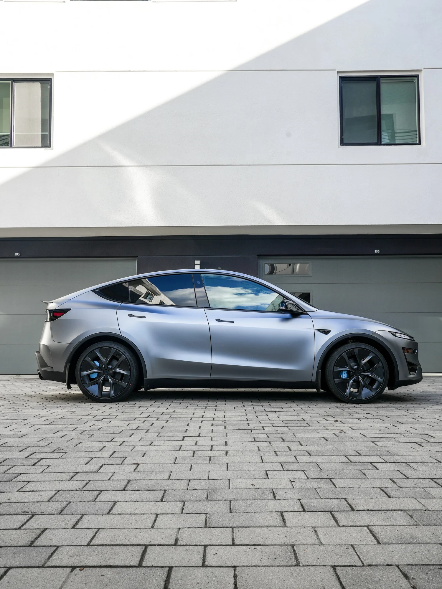 2026 Tesla Model Y Performance full driver-side profile after full XPEL STEALTH PPF and baby blue brake caliper repaint