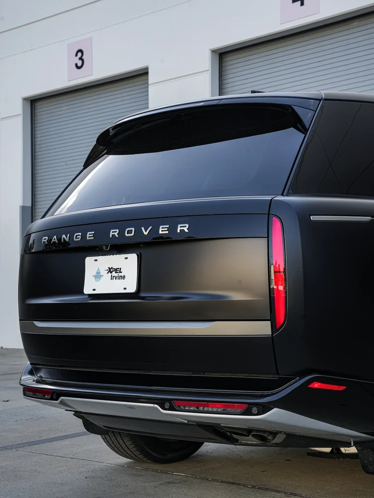 Angled tailgate detail showing the rear glass, vertical taillamp and silver bumper trim.