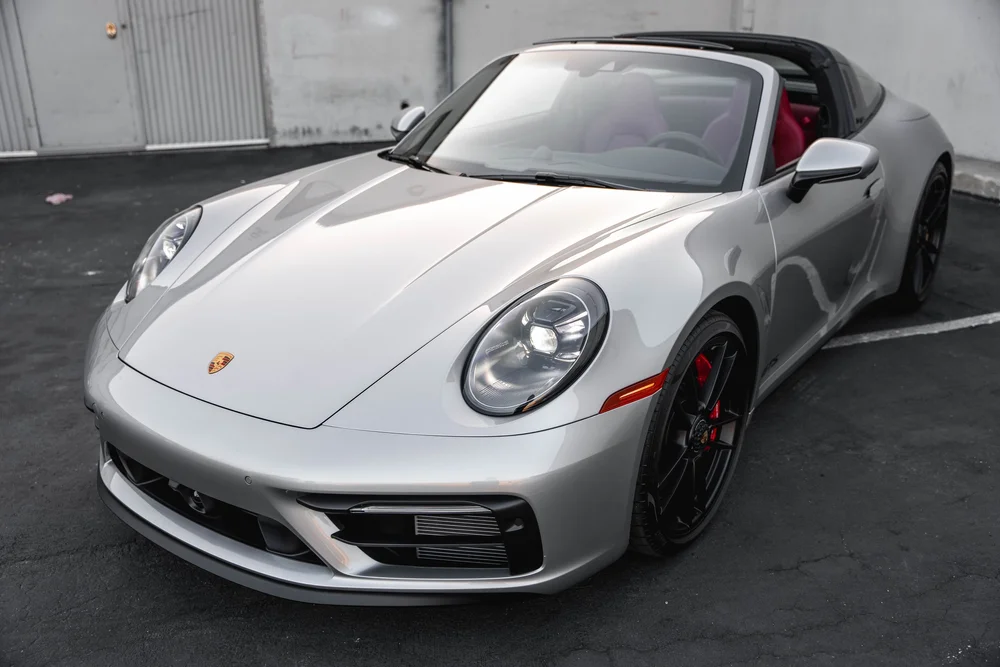 High front three-quarter view of the silver Targa with black wheels and red seats