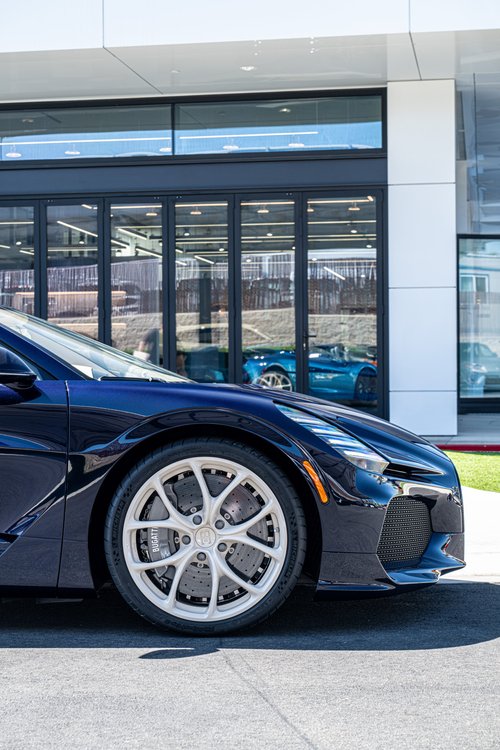 Alternate side close-up of the Bugatti W16 Mistral silver front wheel, Atlantic Blue fender and nose