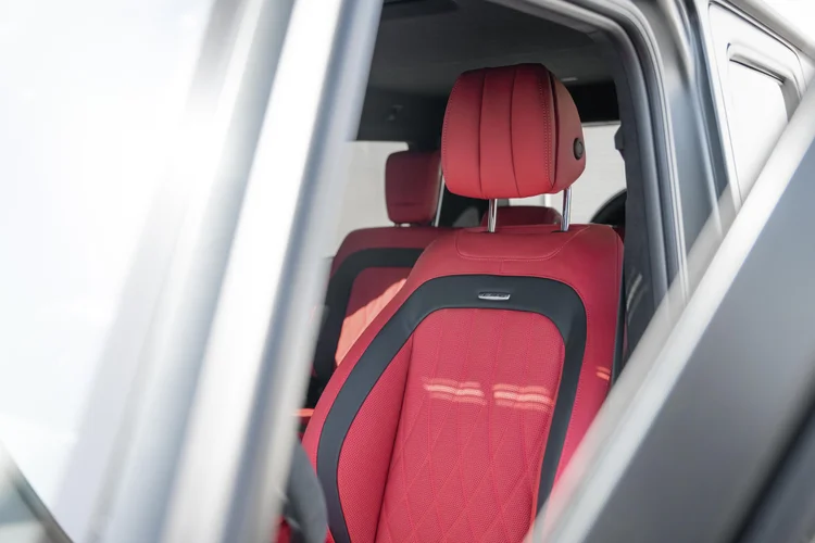 Red-and-black seat and headrest seen through the open side window of the grey G 63