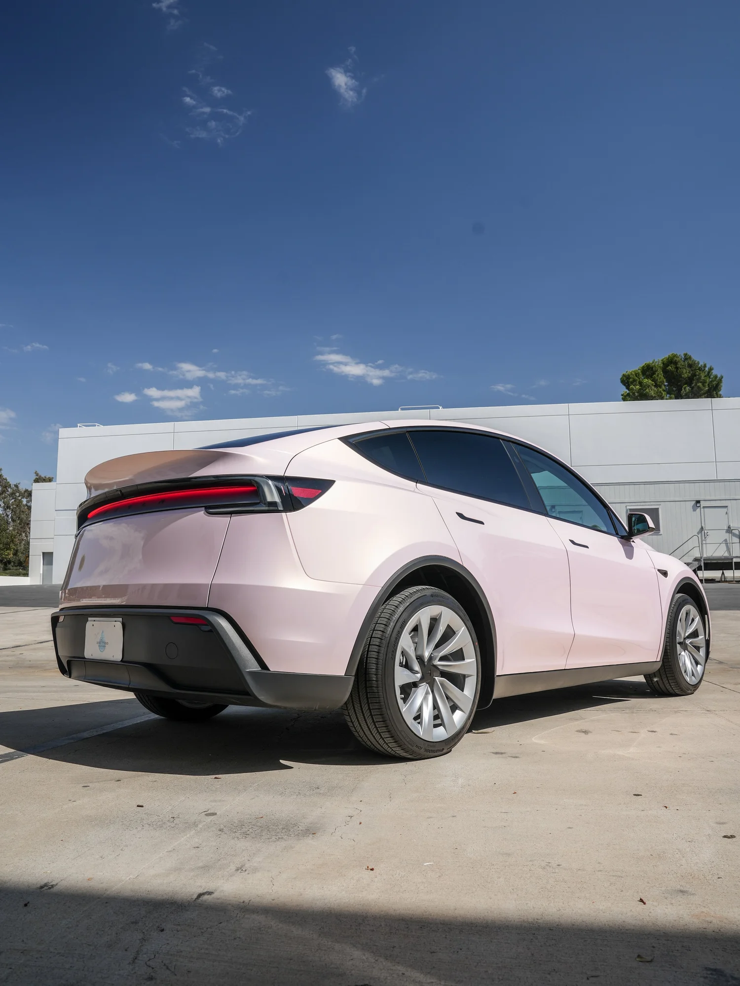 Tesla Model Y Champagne Pink after Vinyl Wrap, rear-right three-quarter view