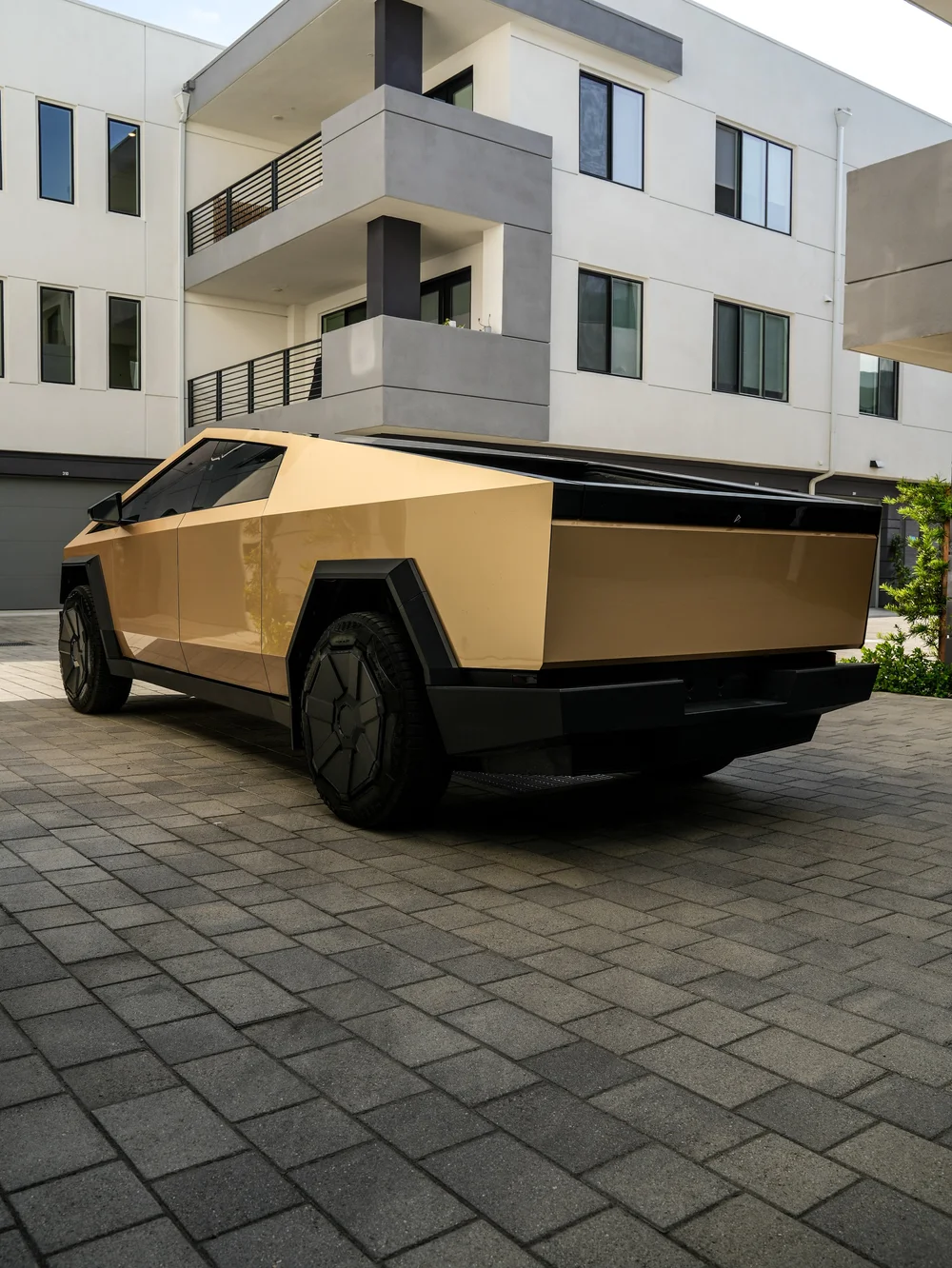 Complete gold Cybertruck rear three-quarter view with dark bed-top trim