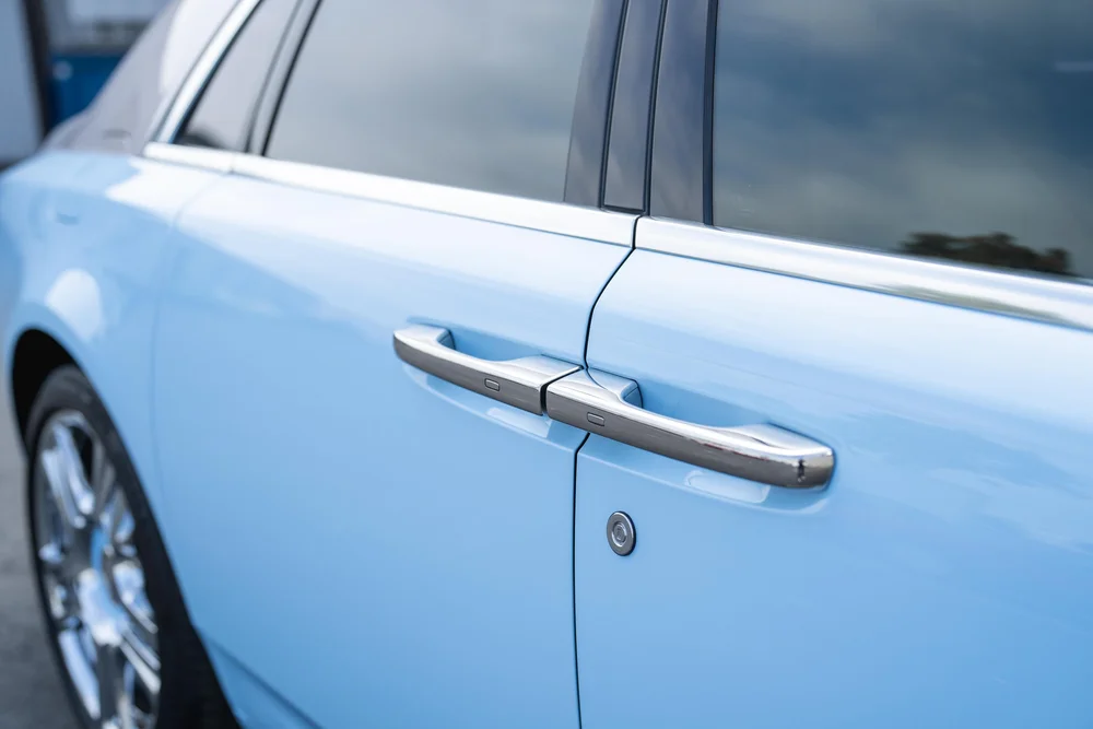 Rolls-Royce Ghost — paired bright door handles, side glass and light-blue body-panel details