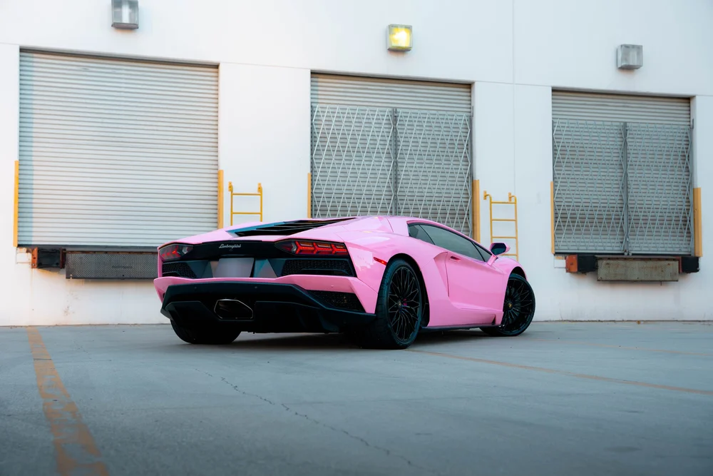Sakura Pink Lamborghini Aventador in a low rear three-quarter view with the doors closed