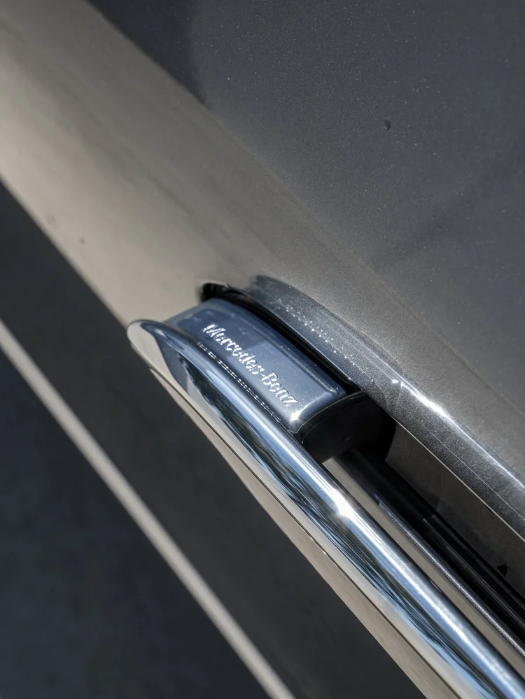 Close-up of the flush door handle and reflective gray bodywork on the Mercedes-AMG EQE 53.