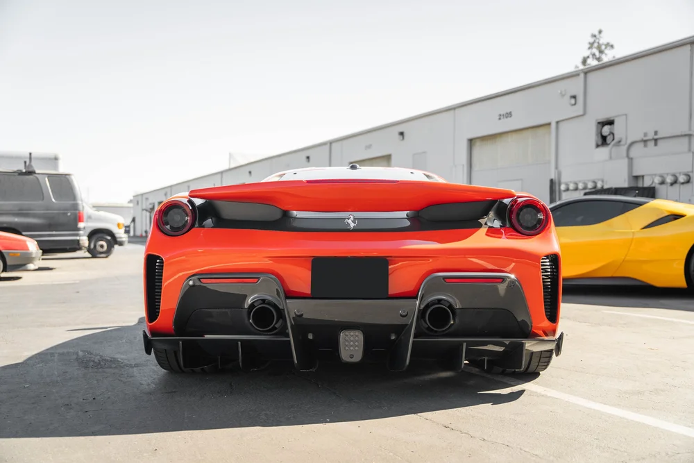 Centered rear view of the Ferrari 488 Pista, showing circular taillights, two exhaust outlets and the rear diffuser