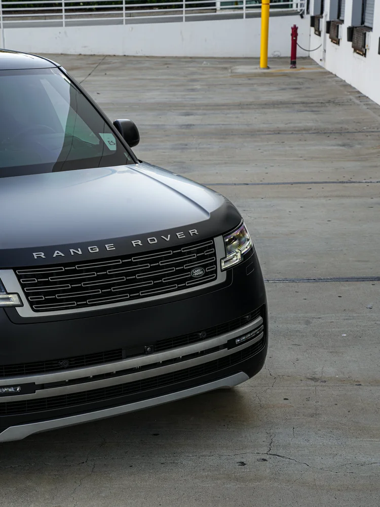 Angled close-up of the bonnet, grille lettering and front bumper, with the vehicle cropped at the left edge.
