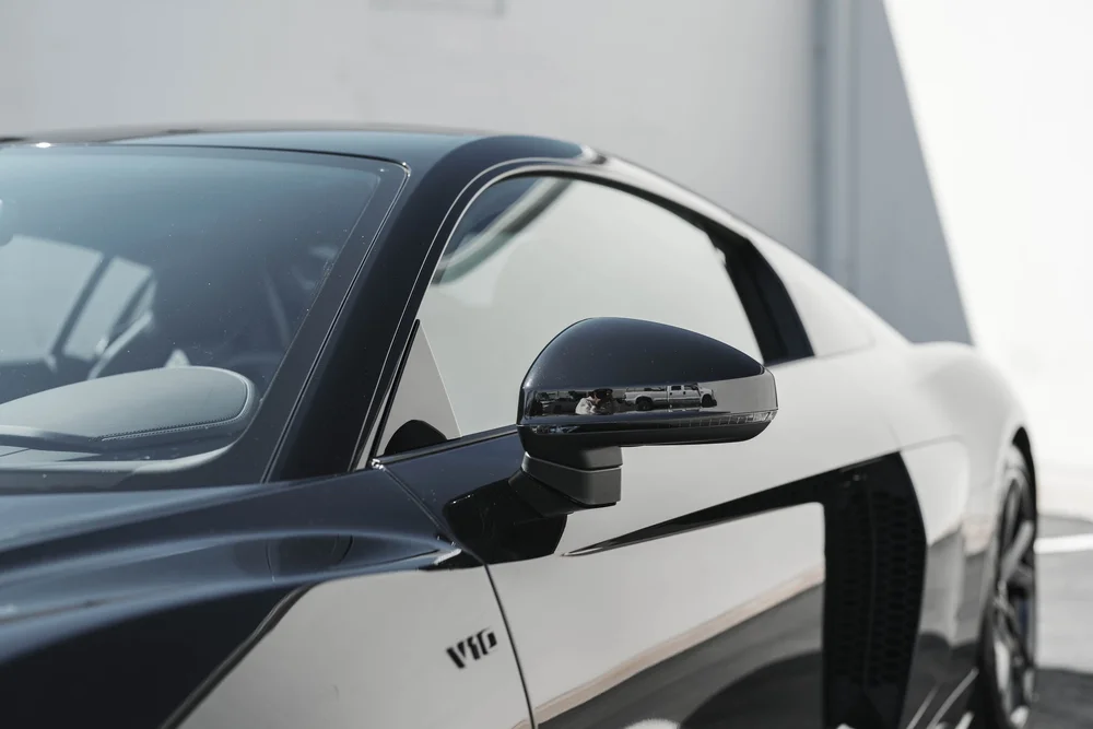 Audi R8 side glass, dark mirror and sculpted door beside the black side intake