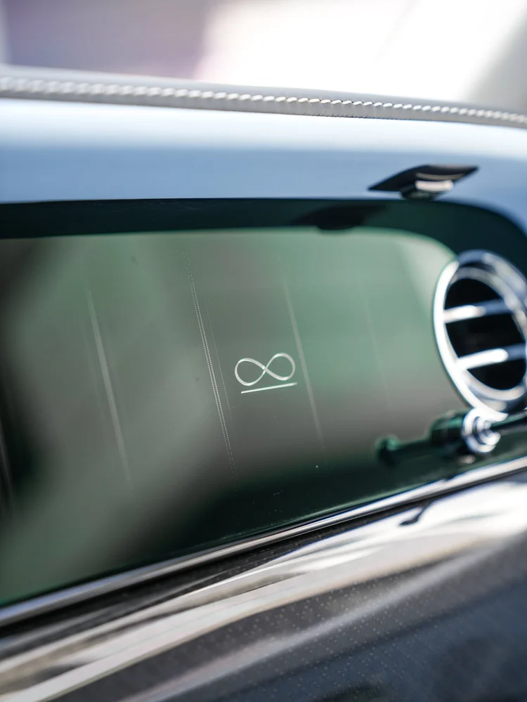 Infinity emblem on the Cullinan dark dashboard beside a circular chrome air vent
