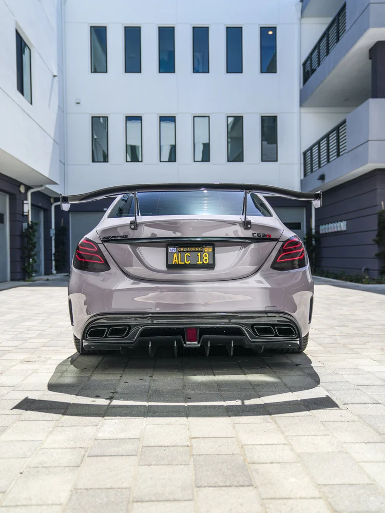 Straight rear view of the light-grey C 63 S showing the rear wing, AMG and C 63 S badges and four exhaust outlets