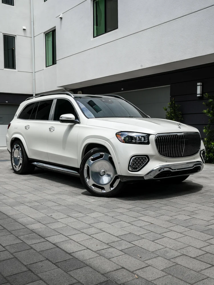 Lower front three-quarter view of the white Mercedes-Maybach GLS 600 with its complete grille, side plane, wheels and chrome bumper.