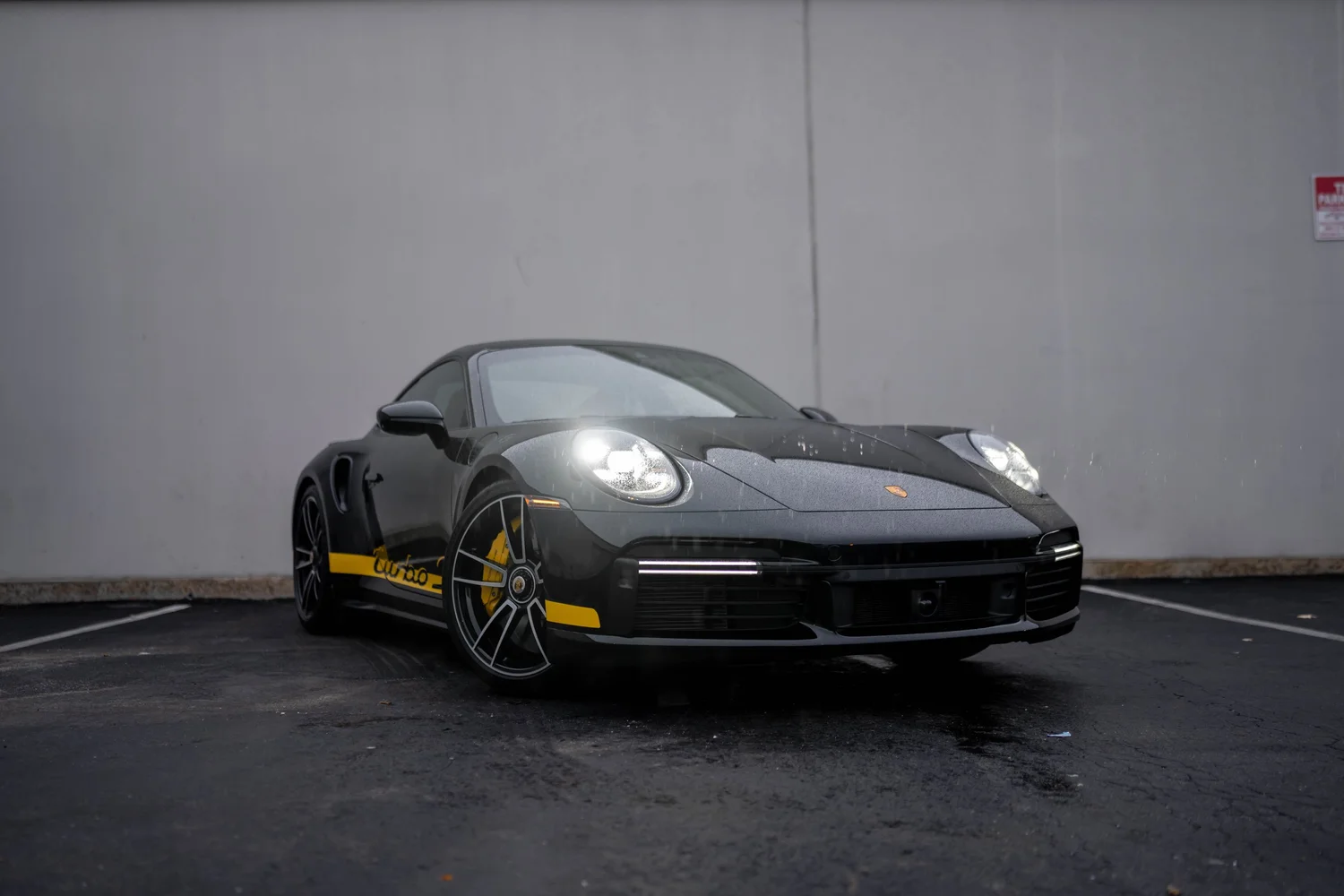 Front three-quarter view of the protected black Porsche 911 Turbo S