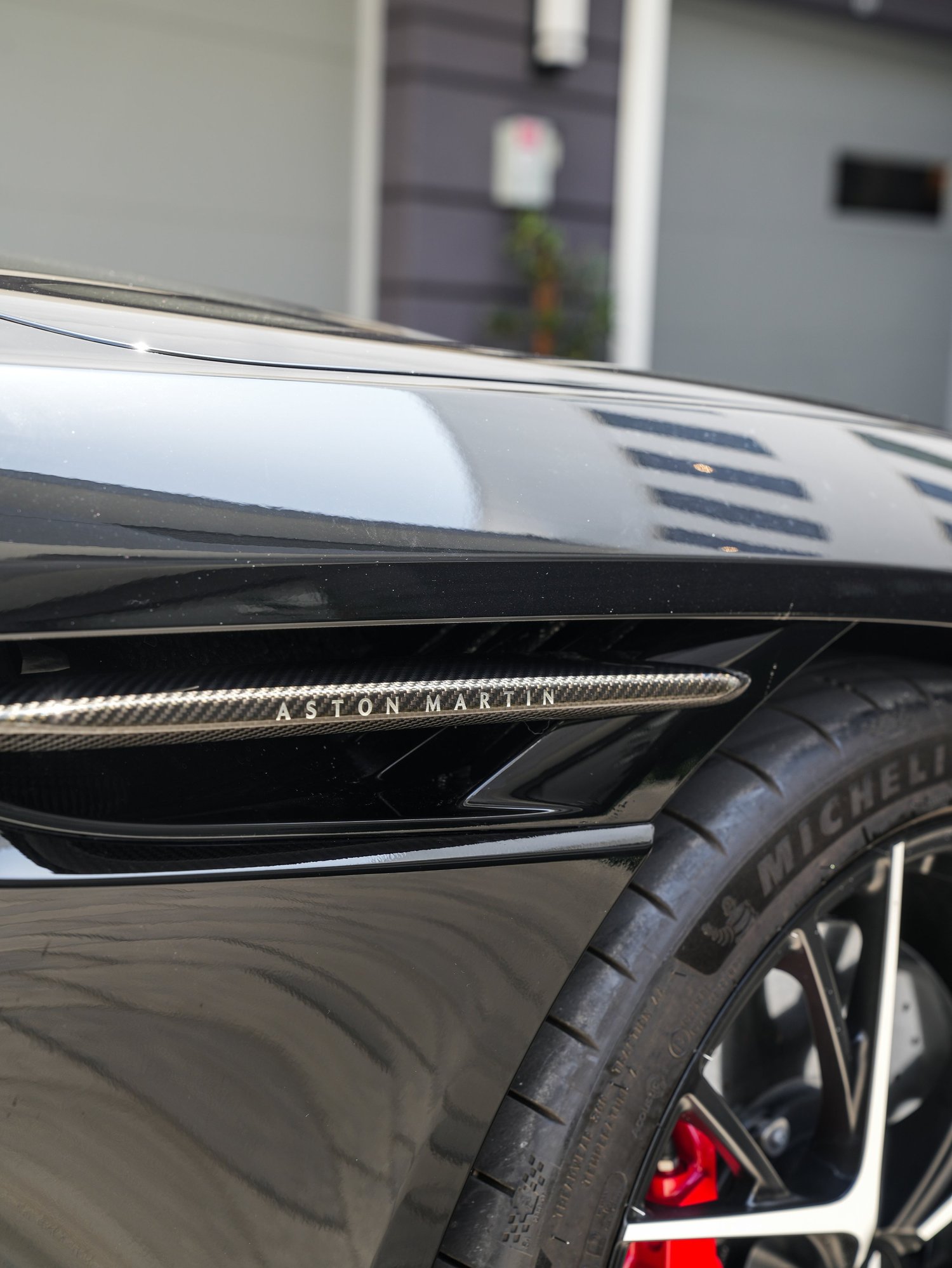 Aston Martin DB12 carbon-fiber fender vent and front wheel detail after full exterior PPF, window tint and ceramic coating