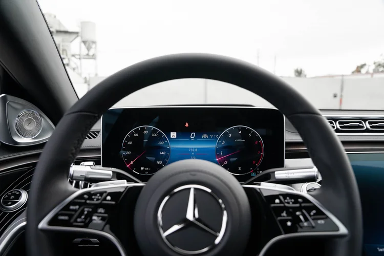 Driver view of the Mercedes-star steering wheel and digital instrument display with circular gauge graphics