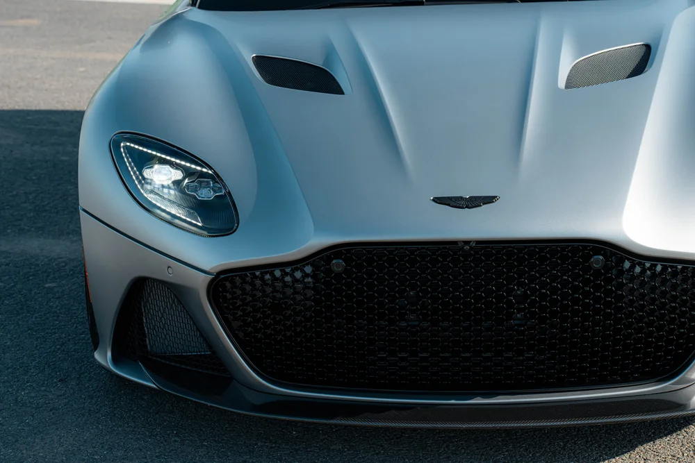 Elevated close view of the DBS matte hood, vents, wing badge and front grille