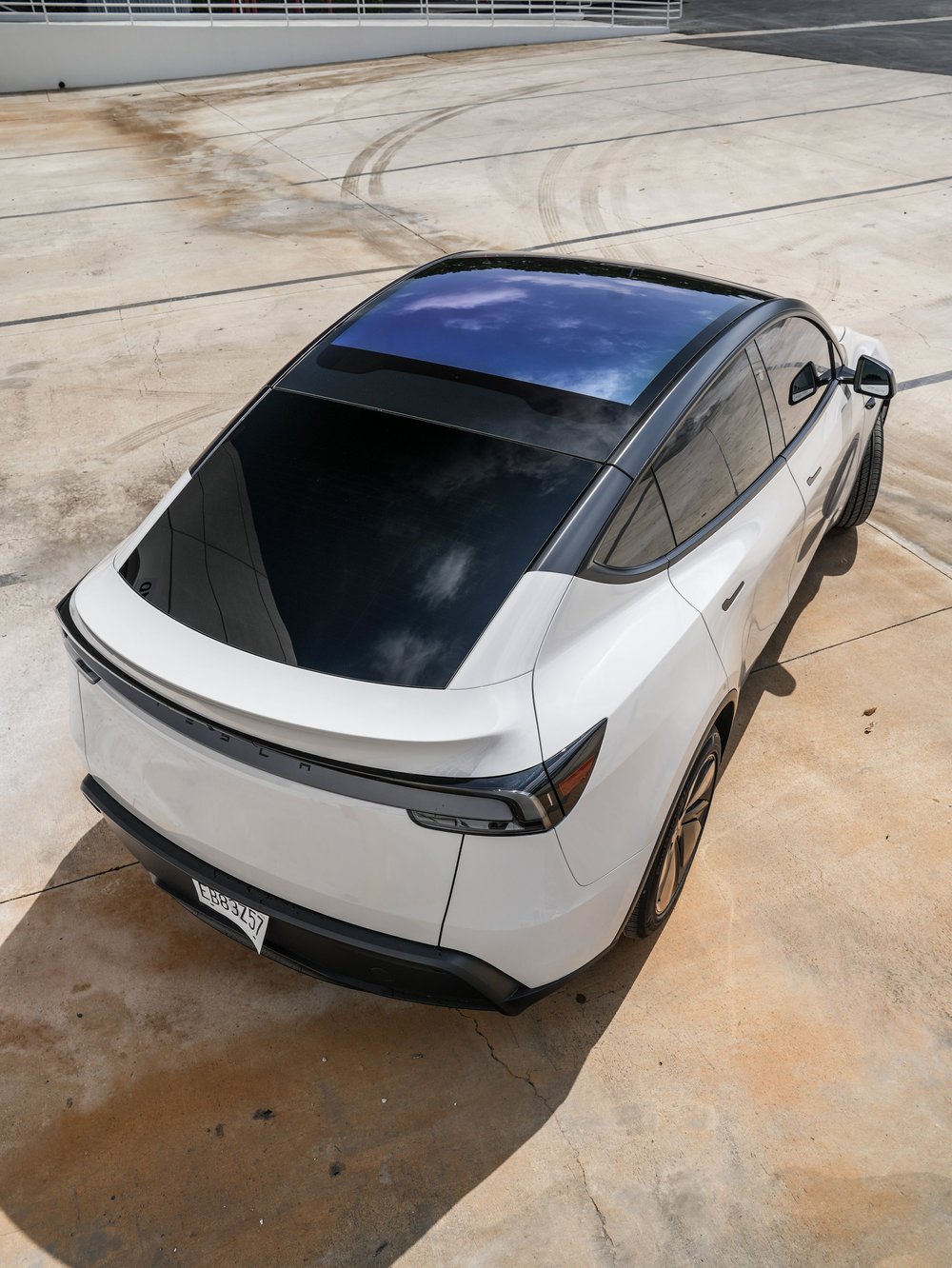 Elevated rear view of the Chalk Grey Model Y with contrasting black roof