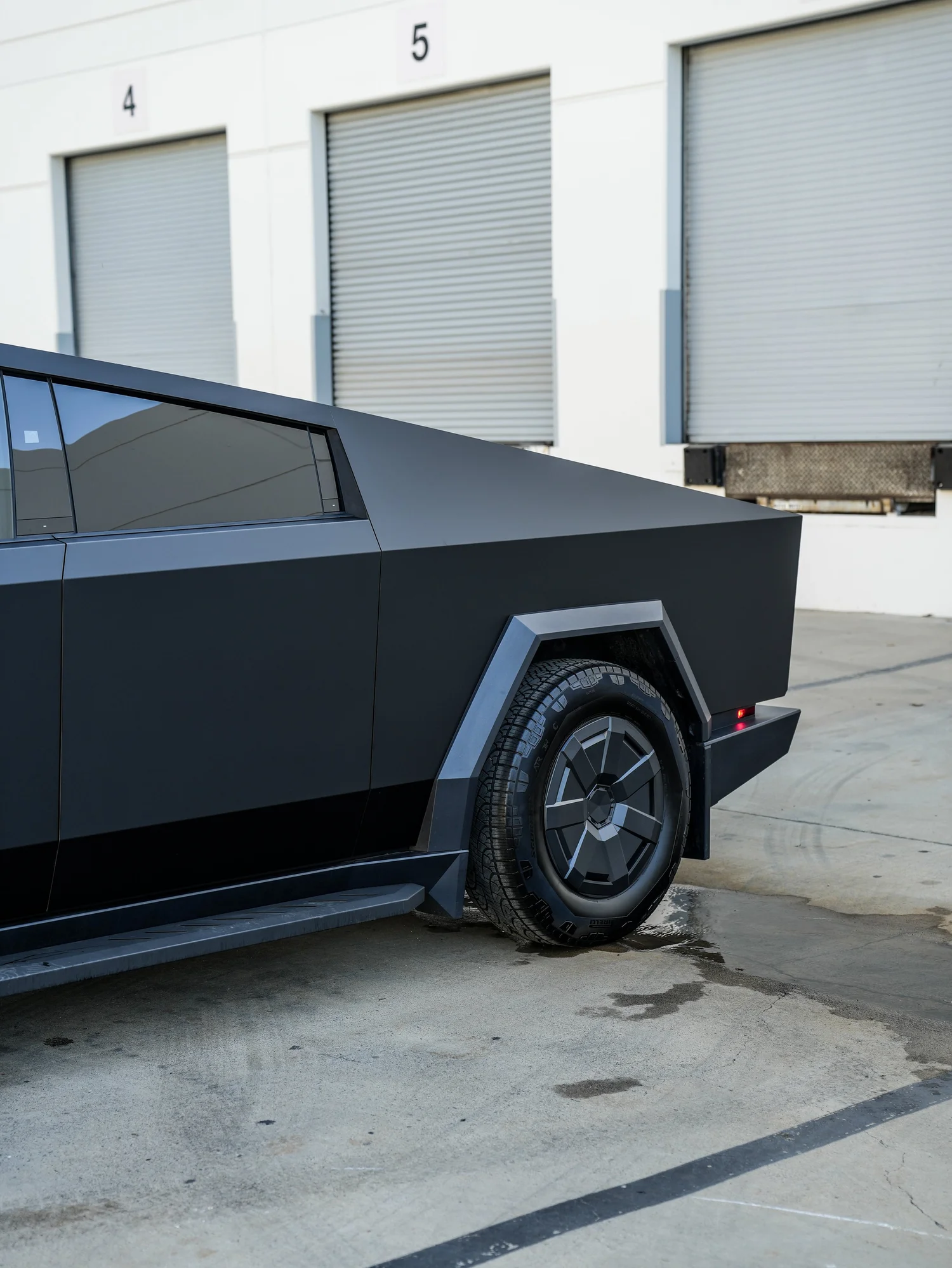 Tesla Cybertruck driver-side rear quarter and wheel detail after PROTEK matte black PPF and window tint