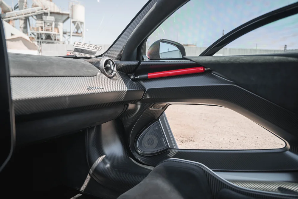 McLaren Senna interior door panel with a lower glass opening and red trim