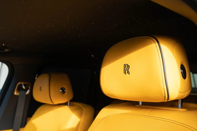 Yellow RR-embroidered headrests beneath a dark ceiling dotted with lights.