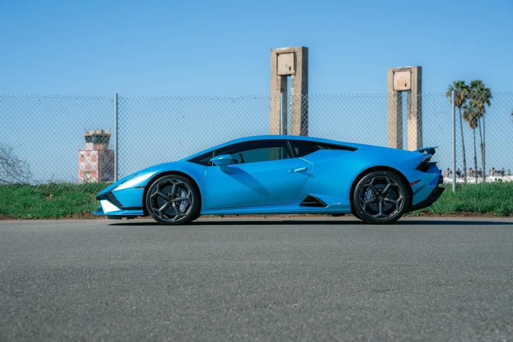 Blue Lamborghini Huracán Tecnica in a complete side profile with grey wheels and closed windows