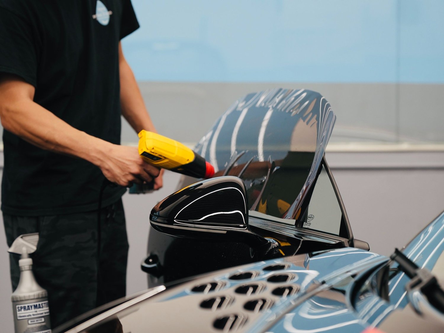 Window film installation on a black performance vehicle inside Toyz Detail Studio