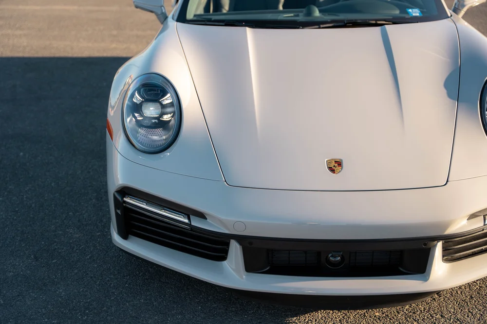 Chalk Porsche 911 Turbo S, high hood, Porsche crest and front-headlight detail