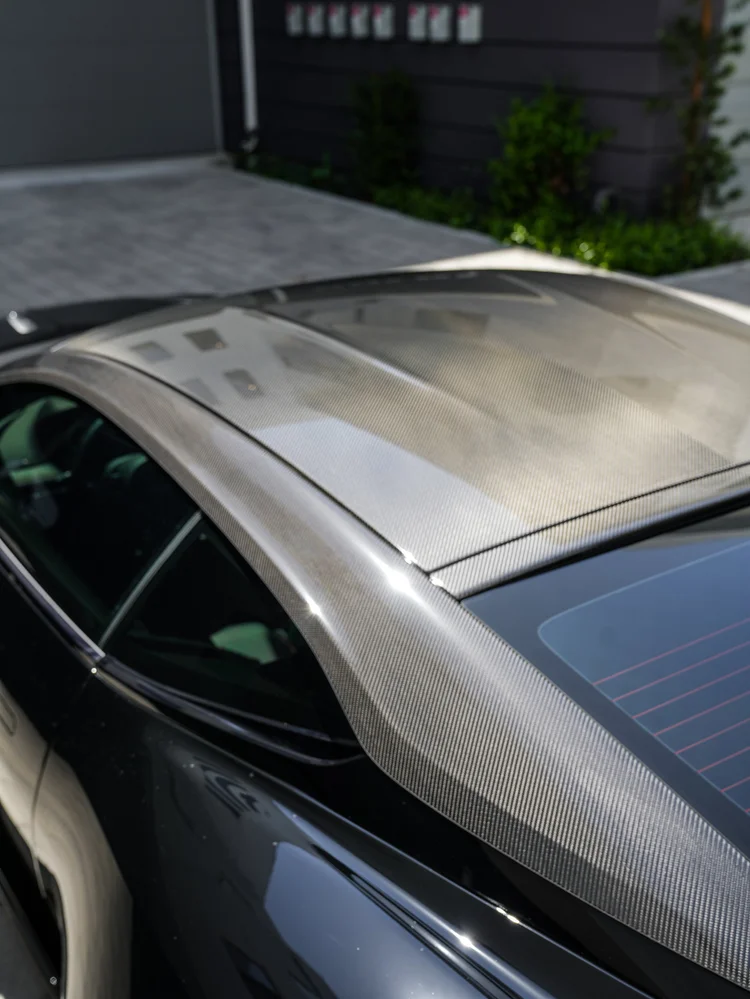Weave-pattern DB12 roof and pillar surfaces beside side and rear glass.