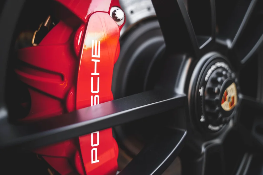 Close-up of the Targa black wheel spokes and red Porsche brake caliper