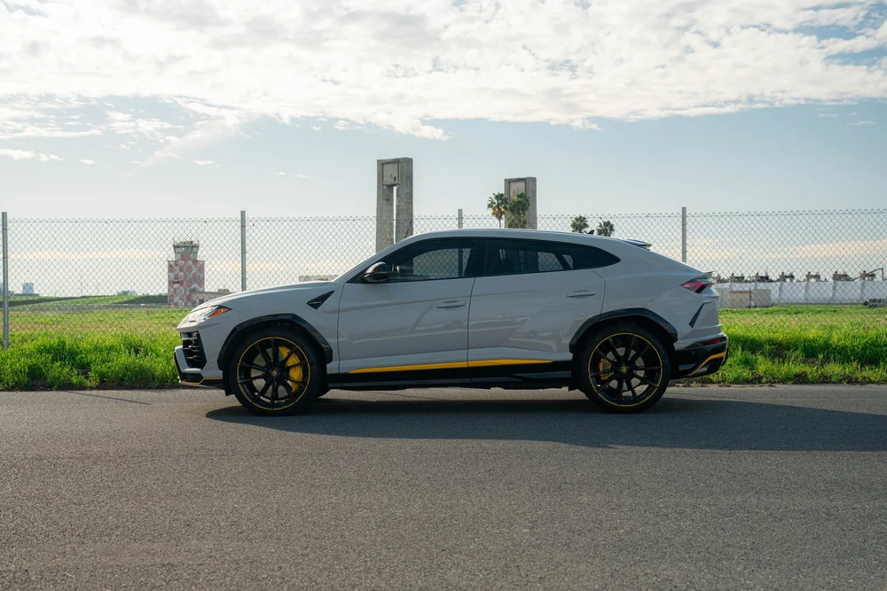 Lamborghini Urus with Chalk vinyl wrap, complete side profile with dark wheels, yellow calipers and lower side accent
