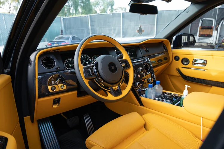 Yellow cabin with a matching steering wheel, dashboard and open front door.