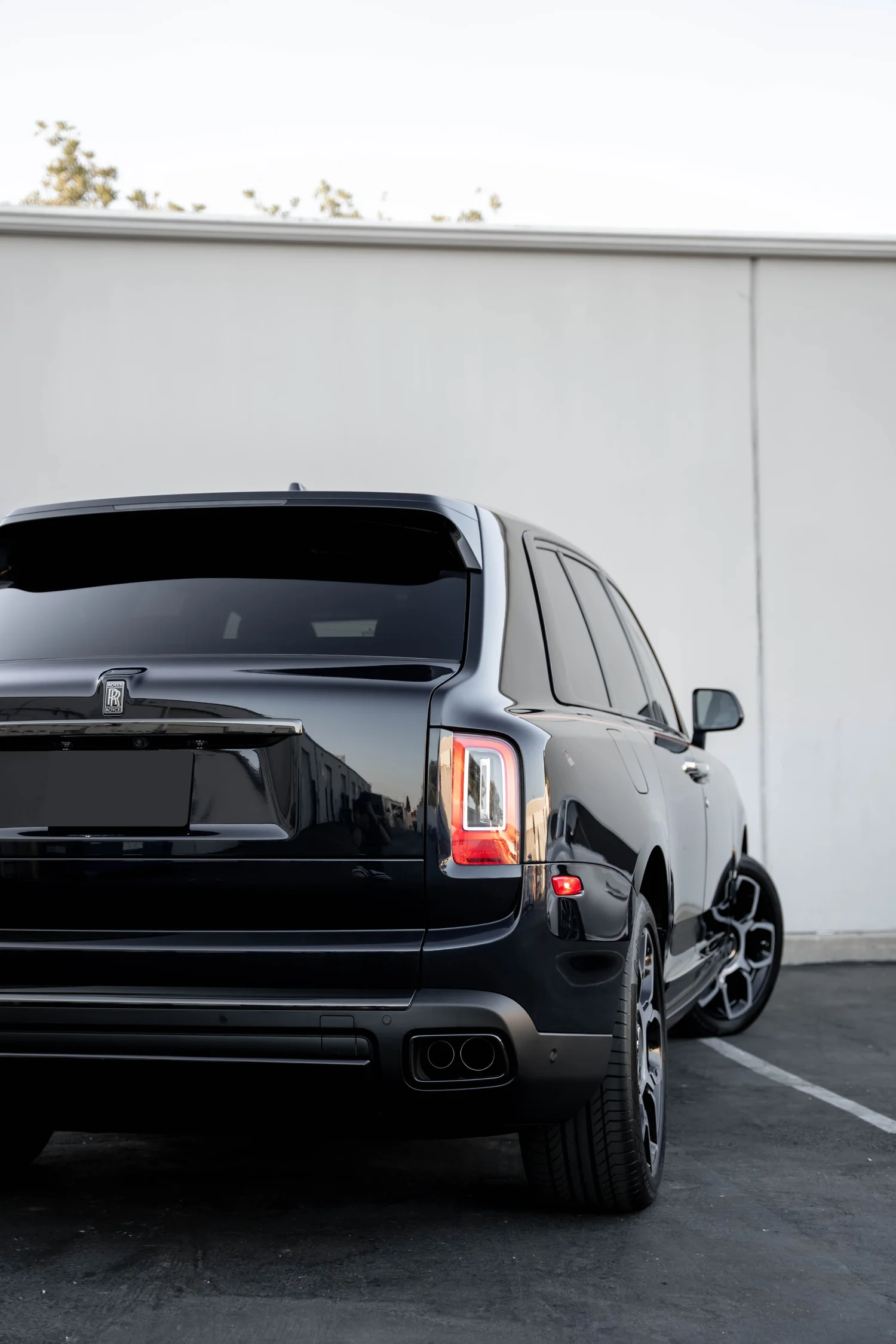 Black Rolls-Royce Cullinan Black Badge after Paint Protection Film (PPF), Window Tint and Ceramic Coating, low-angle rear view