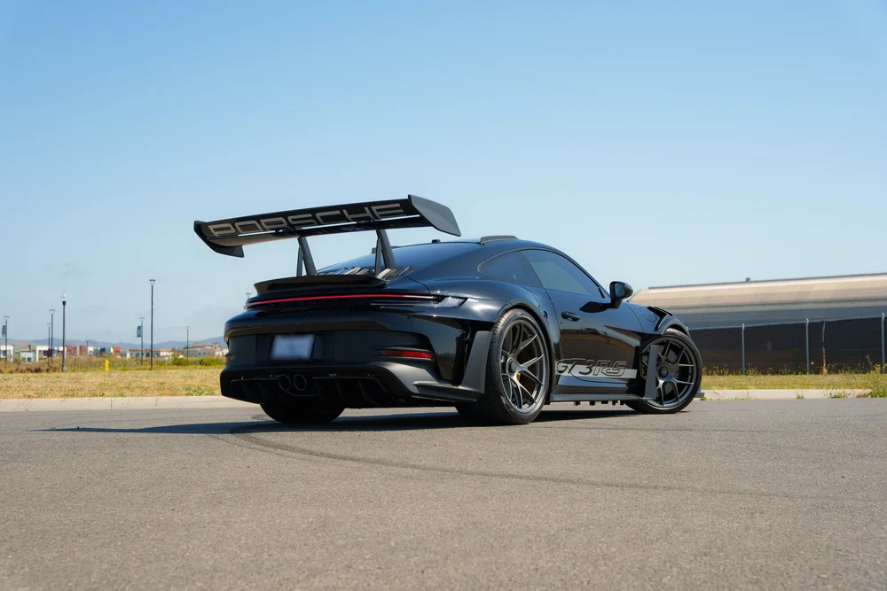 Black Porsche 992.1 GT3 RS, complete low rear three-quarter with large wing
