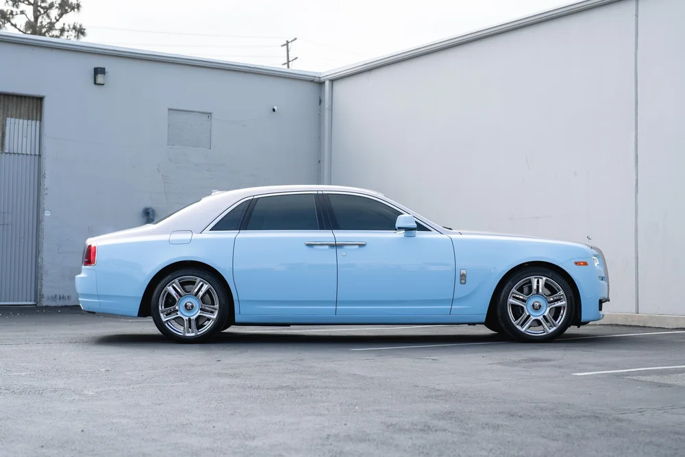 Rolls-Royce Ghost — full sedan side profile with contrasting light-blue and silver-toned panels