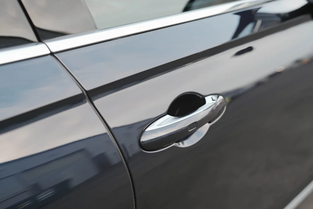 Close view of the door handle and reflections across the side panel.