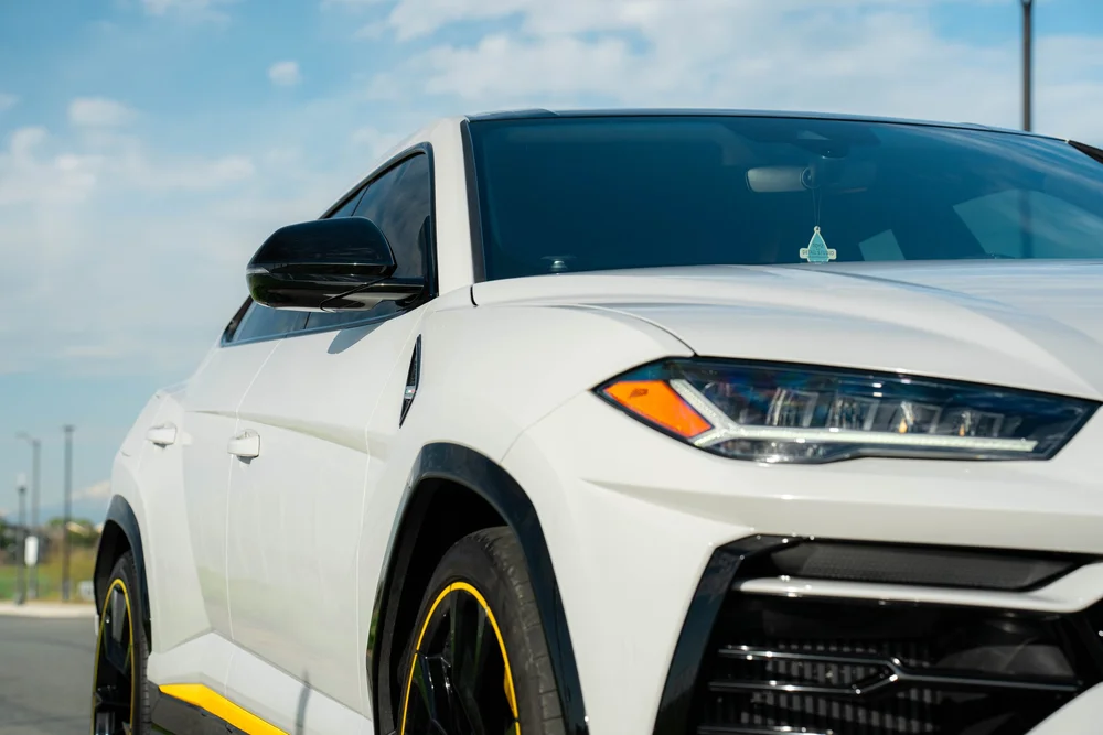 Lamborghini Urus with Chalk vinyl wrap, front-corner detail of headlamp, mirror and reflective side bodywork
