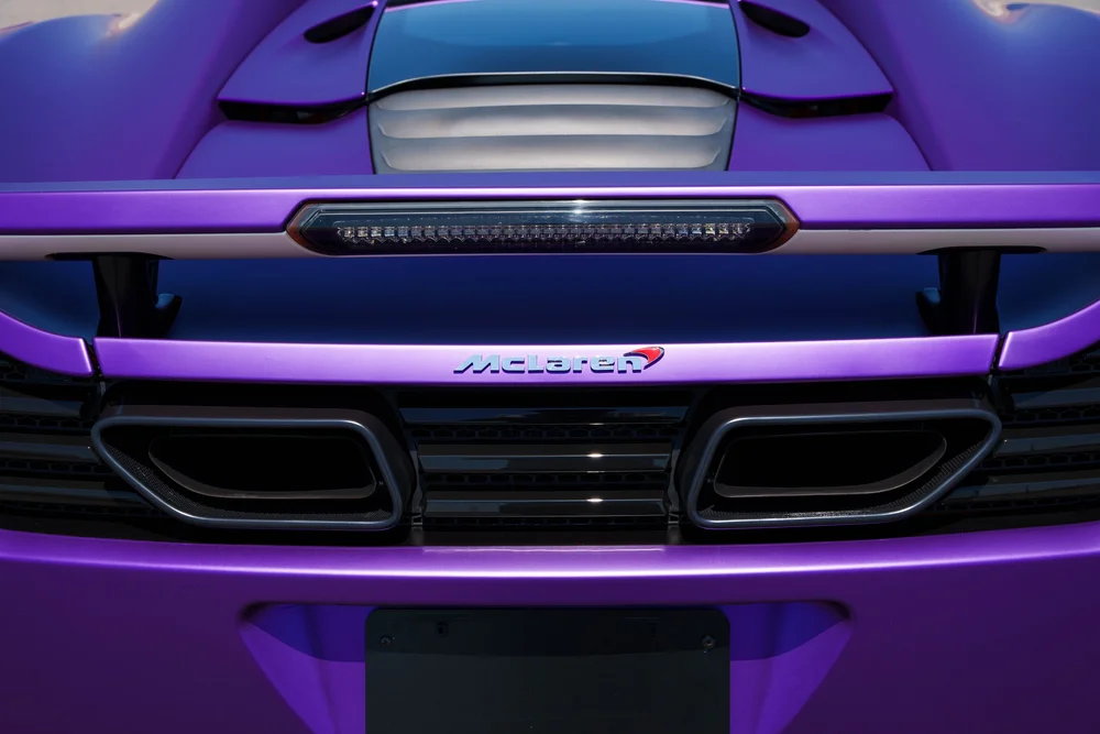 McLaren MP4-12C — centered elevated rear detail with the spoiler, McLaren badge and twin exhaust outlets