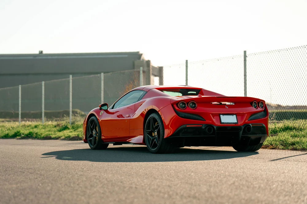 Complete rear three-quarter view of the red Ferrari F8 with black wheels and glossy red bodywork