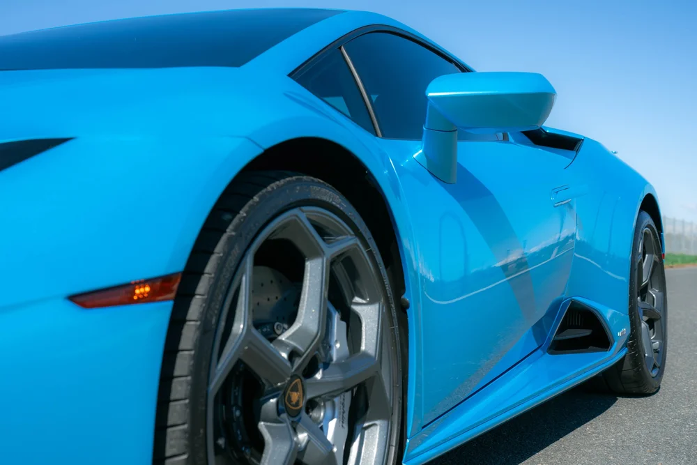 Blue Lamborghini Huracán Tecnica mirror, closed side glass, door and grey front wheel