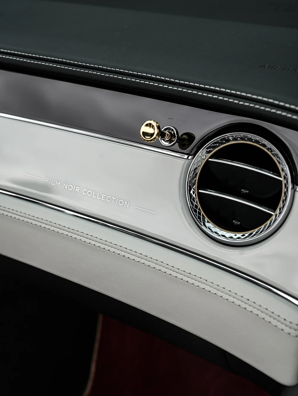 Film Noir Collection lettering on the Bentley passenger dashboard beside the round air vent and gold-toned control.
