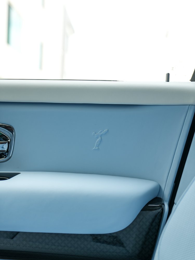 Pale blue Cullinan door upholstery with an embroidered Spirit of Ecstasy motif above dark patterned lower trim