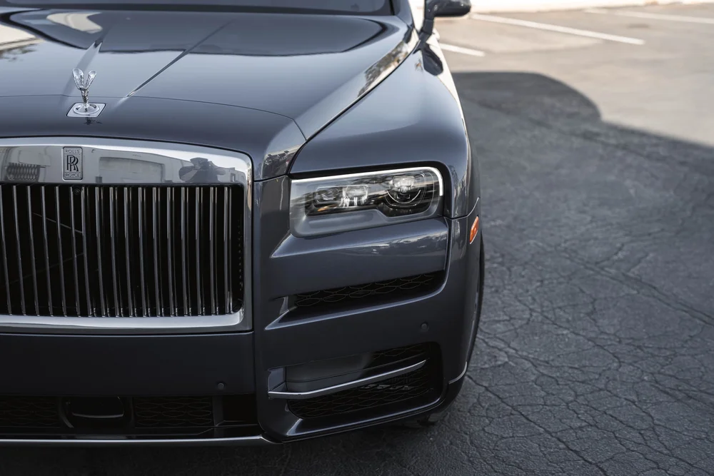 Dark Blue Rolls-Royce Cullinan — close finished hood, grille and headlamp area in a landscape front detail