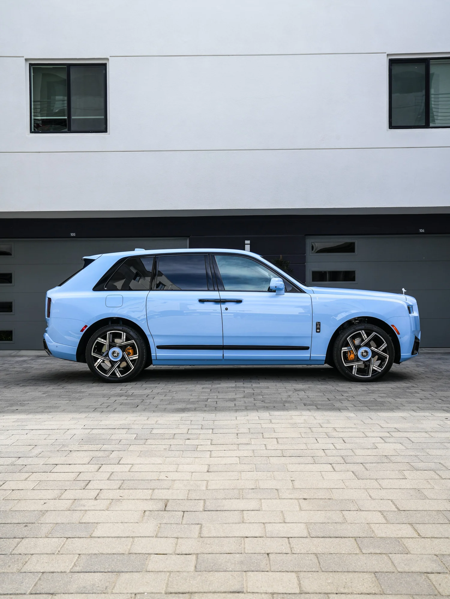 Full side profile of the Powder Blue Cullinan Series II Black Badge with dark glass and gold brake calipers