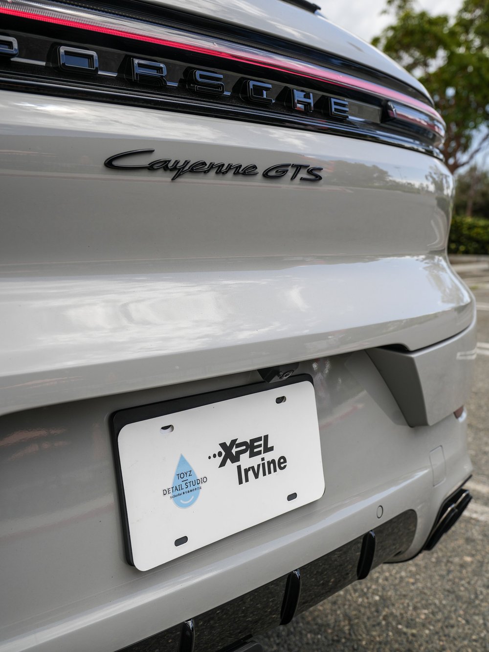 Cayenne GTS rear badge, Porsche lettering and bumper detail above the display plate.