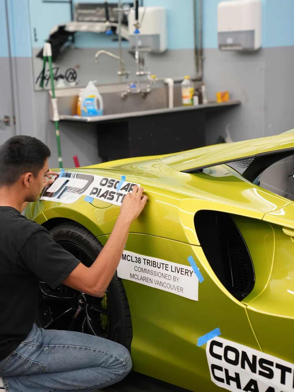 Installer positioning Oscar Piastri graphics on the Artura rear quarter